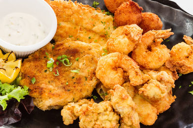 Fried seafood platter with fish, shrimp, hush puppies, and tartar sauce