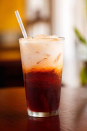 Thai iced tea with layers and a straw